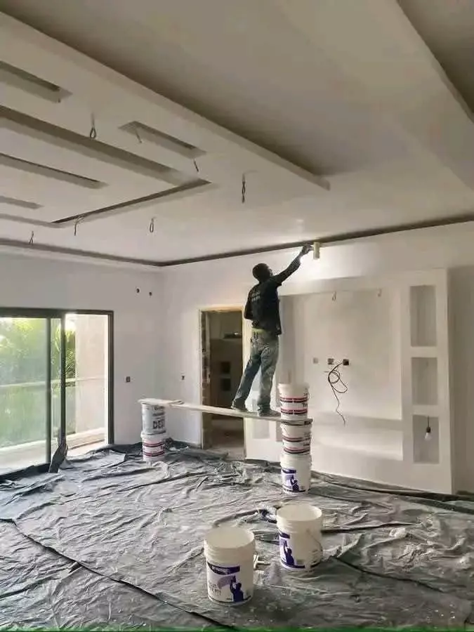 Painter painting a ceiling in a room under renovation