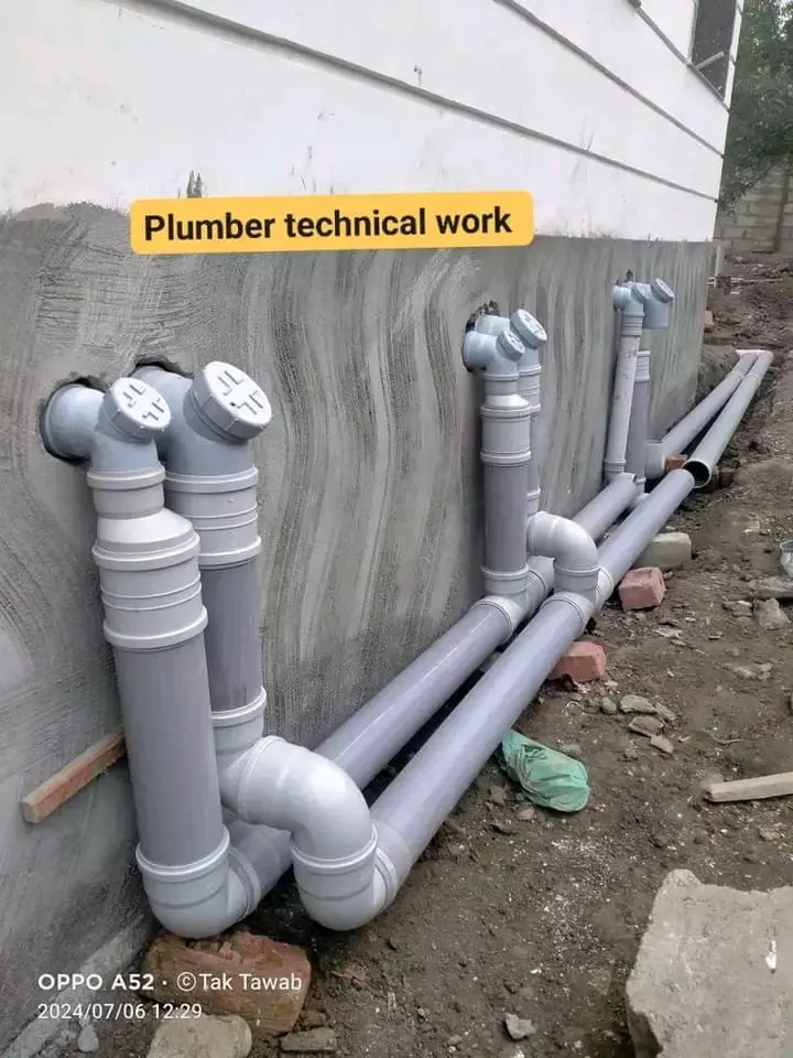 Grey PVC plumbing pipes installed along an exterior wall