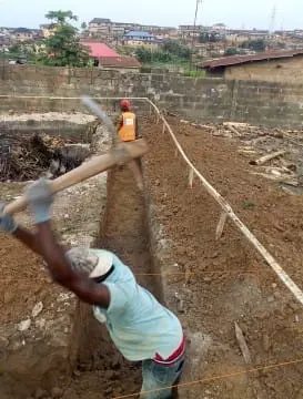 Construction workers digging a foundation trench on a building site