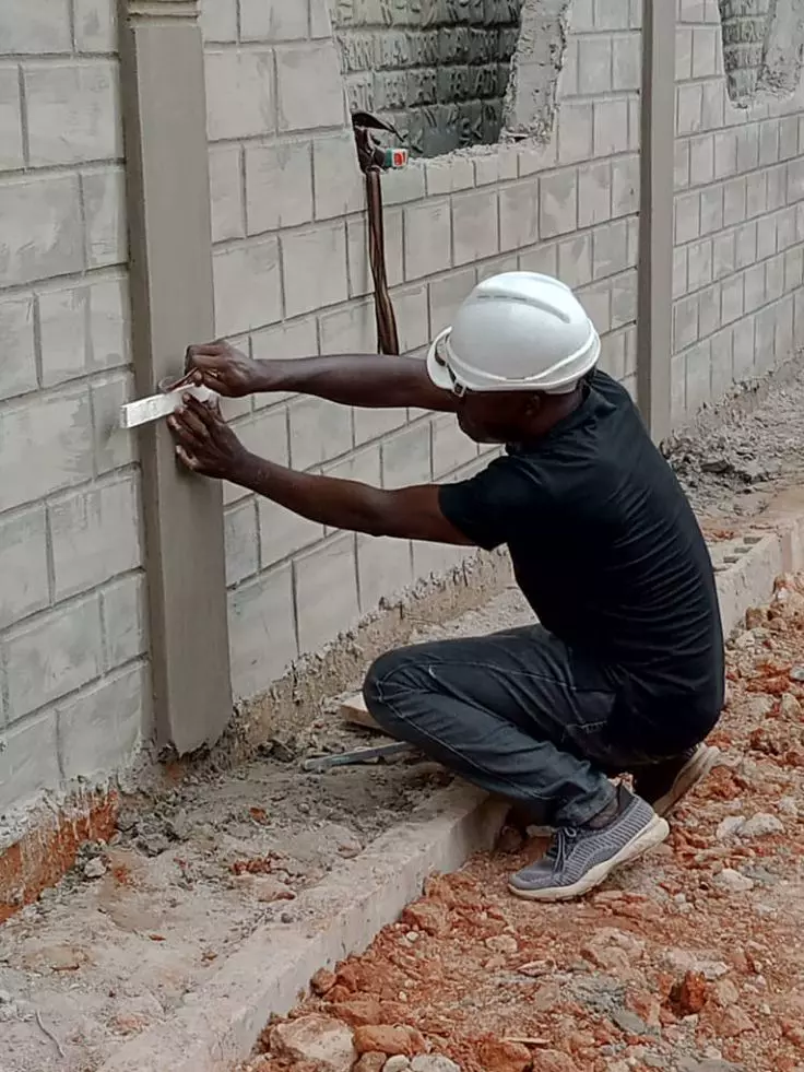Construction worker smoothing a concrete wall