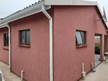 Exterior of a pinkish-red textured residential building