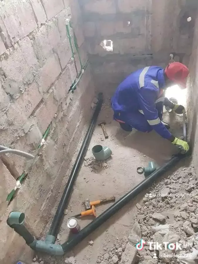 Plumber installing drainage pipes in a construction site